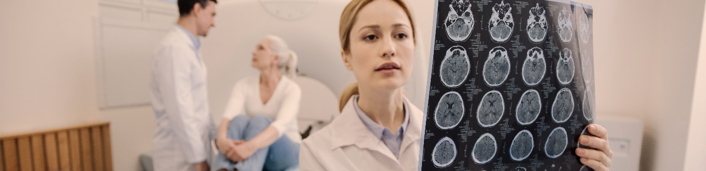 Doctor looking at brain scan with patients in the background