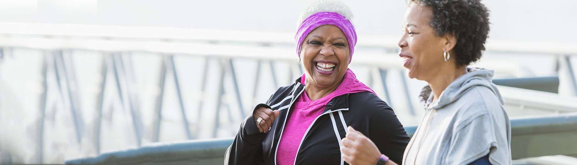 two women power-walking together, laughing